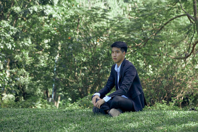 Full length of a young man sitting on land