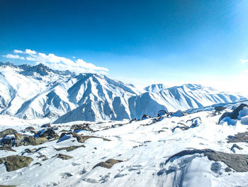 Scenic view of snowcapped mountains against blue sky