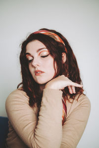 Portrait of young woman sitting on bed at home