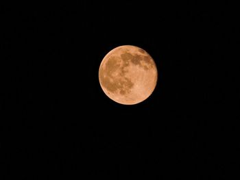 Low angle view of full moon against clear sky at night