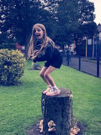 Full length portrait of young woman against plants