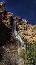 Scenic view of waterfall against sky