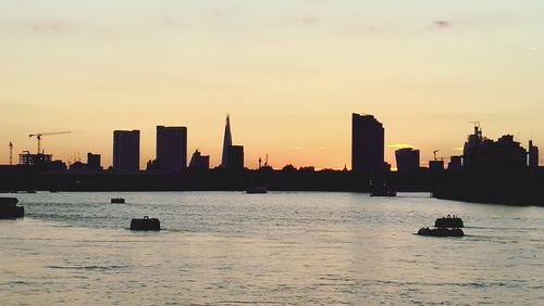 Scenic view of sea and buildings against sky during sunset