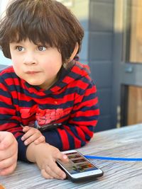 Portrait of boy sitting on table at home