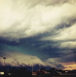 Cars on road against cloudy sky