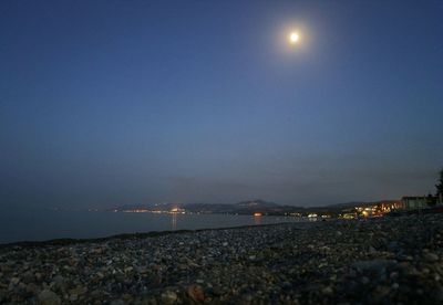 Scenic view of sea against clear blue sky at night