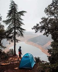 Man in tent on mountain against sky