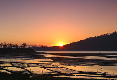 Scenic view of sea against orange sky during sunset