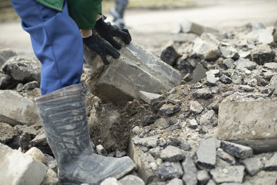 Worker sorts through wreckage of house. construction details. broken stones.