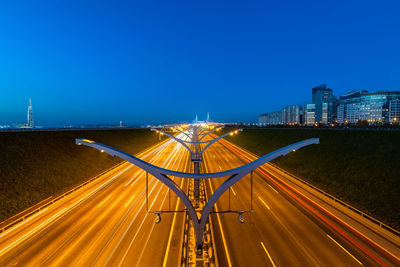 Empty road against clear blue sky