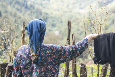 Rear view of women standing against plants