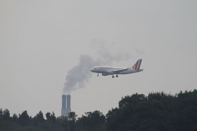 Low angle view of airplane flying against sky