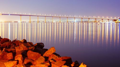 Panoramic view of illuminated bridge at sunset