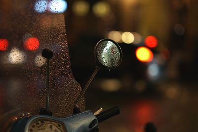 Close-up of motor scooter during rainy season at night