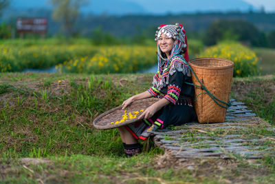 Midsection of woman sitting on field