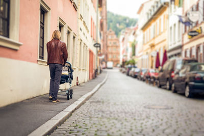 Rear view of woman walking on street in city