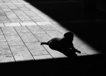 High angle view of person sitting on footpath