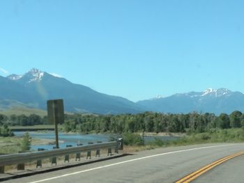 Road by mountains against clear blue sky