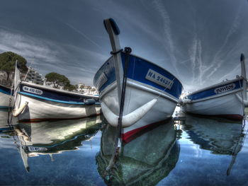 Boats moored on shore against sky