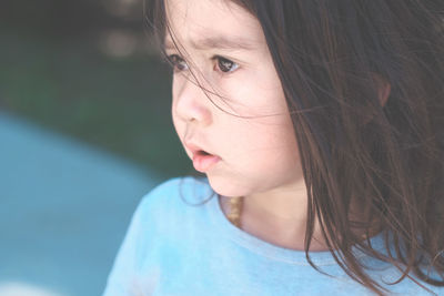 Close-up of cute thoughtful girl looking away