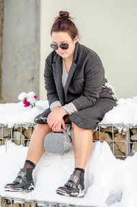 Young woman sitting in snow