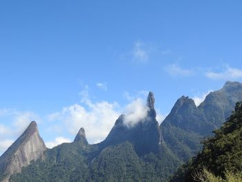 Low angle view of mountains against blue sky