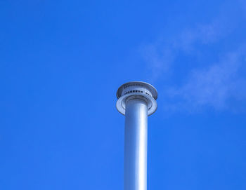 Low angle view of communications tower against blue sky