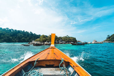 Scenic view of wooden longtail boat sailing in sea against sky