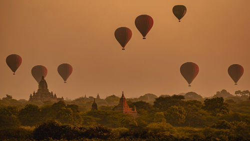 Hot air balloons flying over landscape