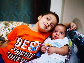 Boy with brother on bed at home 