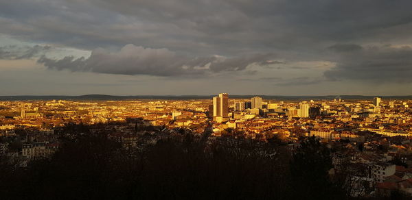 High angle view of buildings against cloudy sky