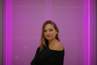 Fashionable young woman in city at night