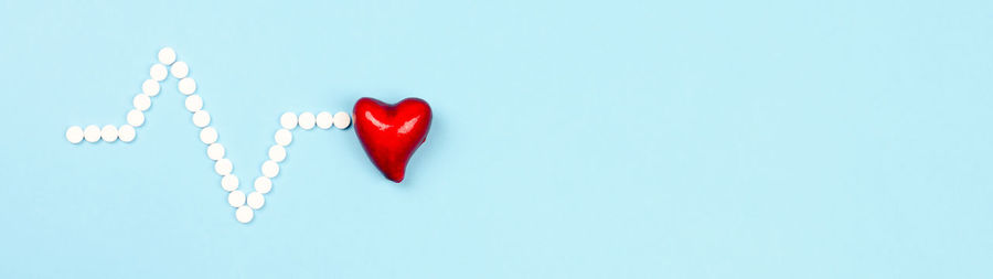 Close-up of red heart shape over white background