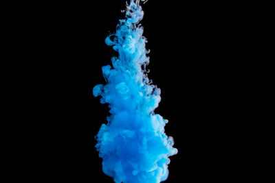 Close-up of blue water splashing against black background