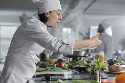 Side view of man preparing food in kitchen