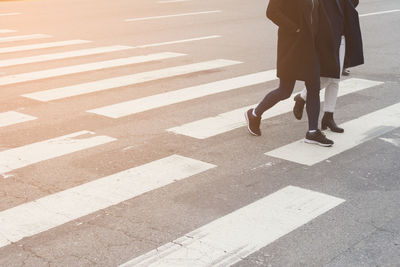 Low section of woman walking on road