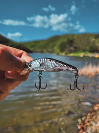 Cropped hand of man holding fishing rod