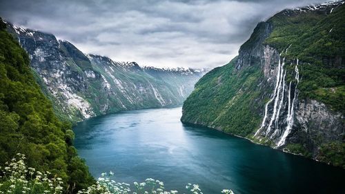 Scenic view of river amidst mountains against sky