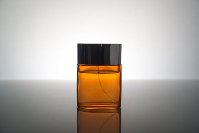 Close-up of perfume on table against gray background