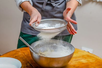 Cook sifts flour through sieve to make dough