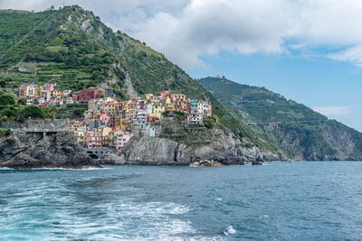 Scenic view of sea by buildings against sky