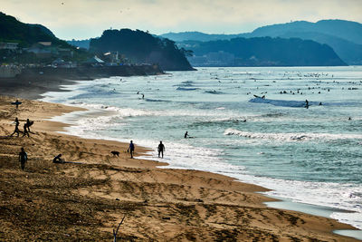 People on beach against sky