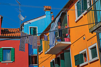 Colorful terraced houses with balcony in burano, a gracious little town full of canals in italy.