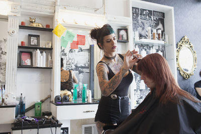 A hair dresser styling a customer's hair.