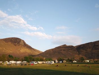 Scenic view of field and mountains against sky