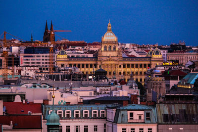 Buildings in city against clear blue sky