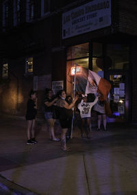 People on illuminated street at night