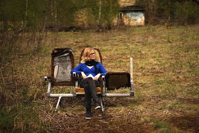 Rear view of woman sitting on grass