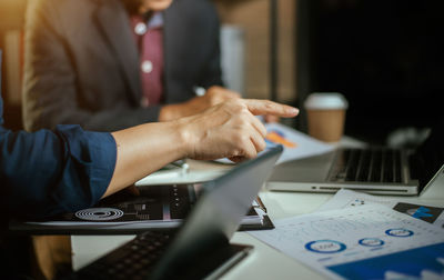 Midsection of man using laptop on table