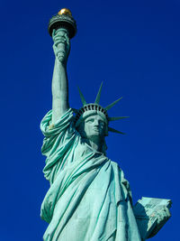 Low angle view of statue against clear blue sky